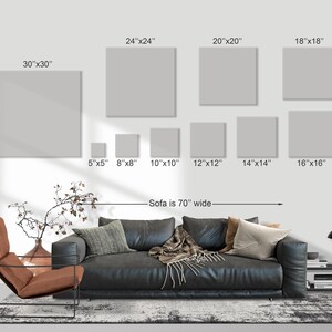 May include: A display of various sized square canvas art prints, ranging from 5x5 inches to 30x30 inches. The text indicates the sofa is 70 inches wide. The canvas prints are displayed on a white wall above a black leather sofa.