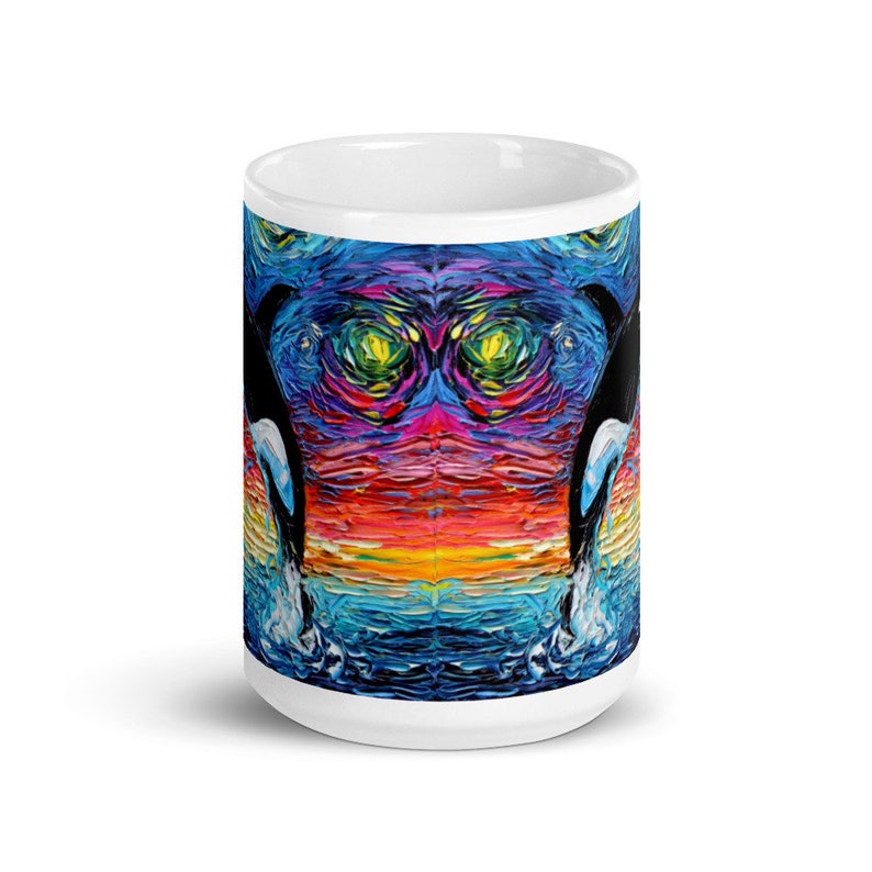 K&ouml;nnte beinhalten: Wei&szlig;e Keramik-Kaffeetasse mit einem farbenfrohen abstrakten Gem&auml;lde von zwei Orcas, die aus dem Wasser springen. Das Gem&auml;lde zeigt einen Regenbogen an Farben, darunter Rot, Orange, Gelb, Gr&uuml;n, Blau und Lila.