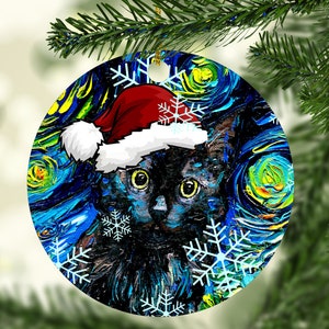 Pu&ograve; includere: Una decorazione rotonda in ceramica raffigurante un gatto nero con un cappello da Babbo Natale rosso e bianco. Lo sfondo presenta un motivo impressionista vorticoso blu e giallo con grafiche di fiocchi di neve bianchi sulla superficie.