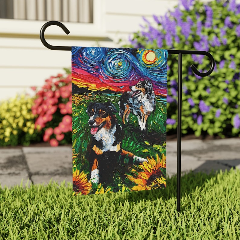 Peut inclure: Un drapeau de jardin repr&eacute;sentant une peinture abstraite color&eacute;e de deux chiens de berger australien dans un champ de tournesols. L'arri&egrave;re-plan est un ciel nocturne &eacute;toil&eacute; avec une lune brillante.