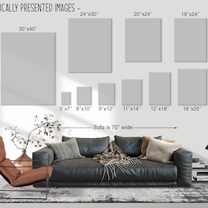 May include: A diagram showing different sizes of framed artwork, with measurements in inches, displayed above a black leather sofa and a brown leather armchair. The text "Sofa is 70" wide" is below the artwork.