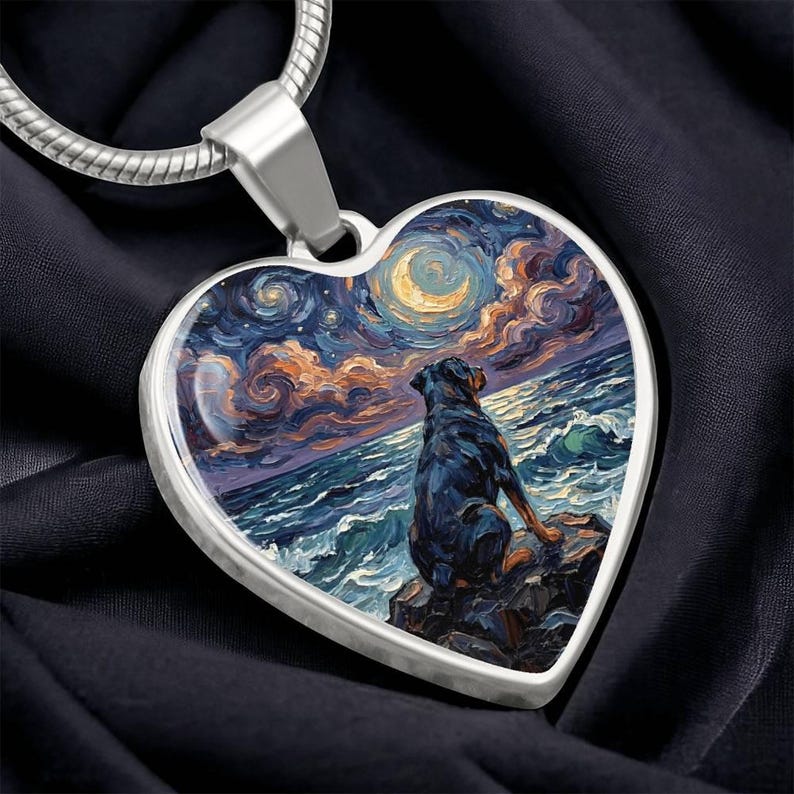 May include: Heart-shaped pendant with a silver chain. The pendant features a painting of a dog sitting on a rock, gazing at a starry night sky over the ocean. The artwork uses blues, oranges, and yellows.