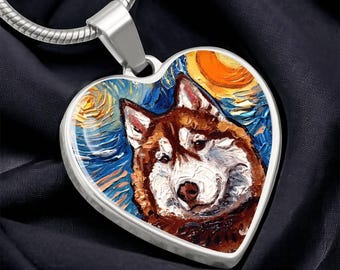 May include: Heart-shaped pendant necklace with a silver chain. The pendant features a colorful painting of a husky dog against a starry night sky. The artwork uses shades of blue, orange, brown, and white.