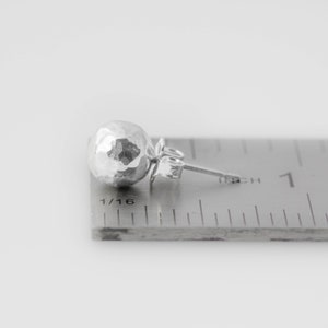 May include: A silver hammered ball stud earring measuring 1/16 inch in diameter.