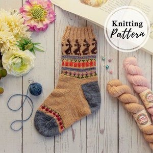 May include: Knitting pattern for a pair of socks with a brown, blue, orange, and purple design. The pattern includes a row of small deer or reindeer. The yarn is pink and beige.