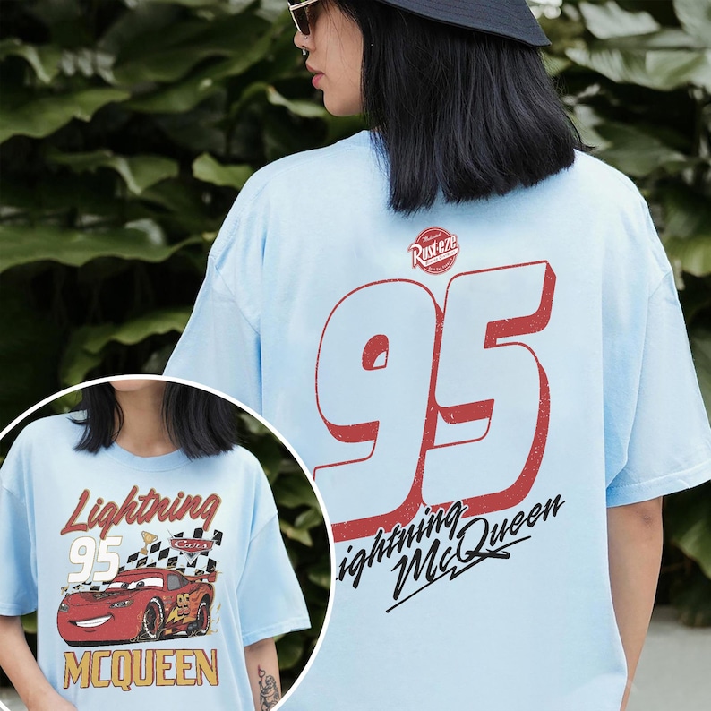 May include: Light blue t-shirt featuring Lightning McQueen from the Cars movie. The front graphic shows the car with the text "Lightning 95 McQueen". The back of the shirt displays a large "95" in red with "Lightning McQueen" below.