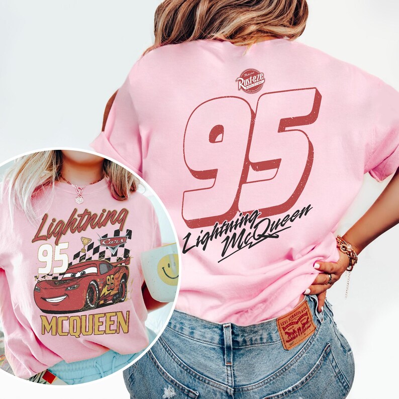May include: Pink t-shirt featuring a graphic of Lightning McQueen from the Cars movie. The front of the shirt displays the text "Lightning 95 McQueen" with an image of the car. The back of the shirt has a large "95" and "Lightning McQueen" text.