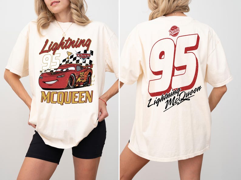 May include: Cream-colored t-shirt featuring a graphic of Lightning McQueen from the Cars movie. The front design includes the text "Lightning 95 McQueen" with a checkered flag. The back displays a large "95" and "Lightning McQueen" text.