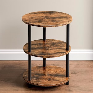 May include: A three-tiered side table with a rustic, distressed wood finish. The round shelves are supported by black metal legs. The table is designed for display or storage and has a compact footprint, making it suitable for small spaces.