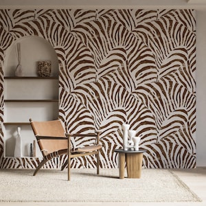 Può includere: Una carta da parati con stampa zebrata marrone e bianca con una sedia in pelle marrone davanti a uno scaffale bianco con alcuni oggetti decorativi.