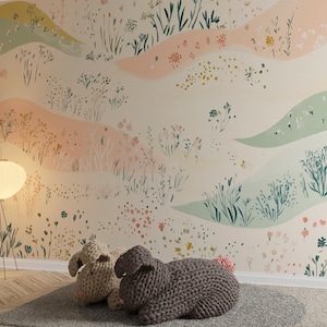 May include: A nursery room with a light pink and green floral wallpaper, a white floor lamp with a white shade, and two knitted bunny toys on the floor.