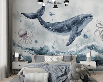 May include: A bedroom with a blue and gray ocean-themed mural featuring a whale, jellyfish, and waves. The bed has gray bedding, a blue blanket, and a whale-shaped pillow. A gray teddy bear sits on the bed, and the room has a gray plaid rug.