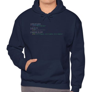 Könnte beinhalten: Marineblauer Kapuzenpullover mit einer Vordertasche und einer Kapuze mit Kordelzug. Der Kapuzenpullover zeigt eine in Weiß und Grün gedruckte Codezeile. Die Person auf dem Bild trägt den Kapuzenpullover.