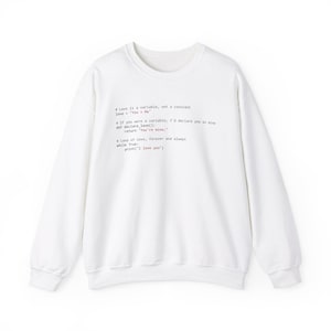 Könnte beinhalten: Weißer Pullover mit einem rosafarbenen und schwarzen grafischen Aufdruck von Code, der lautet: "Love is a variable, not a constant. Love = "You + Me". If you were a variable, I'd declare you as sine. def declare_love(): return "You're mine"; A loop of love, forever and always while True: print("I love you")"