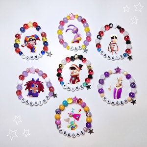 Puede incluir: Una colección de seis pulseras de cuentas con diseños de personajes de dibujos animados. Cada pulsera tiene una combinación de colores única con estrellas y cuentas. Los nombres de los personajes están escritos con cuentas de letras blancas.