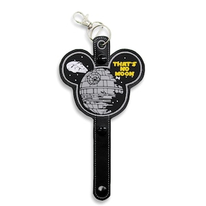 May include: Black and white Mickey Mouse-shaped keychain featuring a Death Star and a TIE fighter in the background. The text "That's No Moon" is written in yellow.