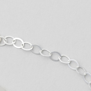 Puede incluir: Un collar de cadena de plata con eslabones ovalados.