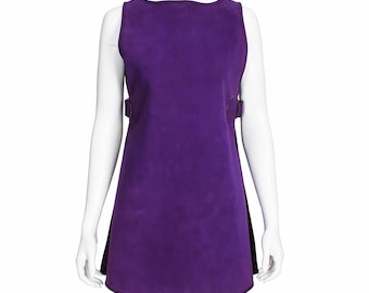 May include: A sleeveless, purple dress with a slight A-line silhouette. The dress features a rounded neckline and two decorative buckle details on each side. The dress is displayed on a white mannequin.