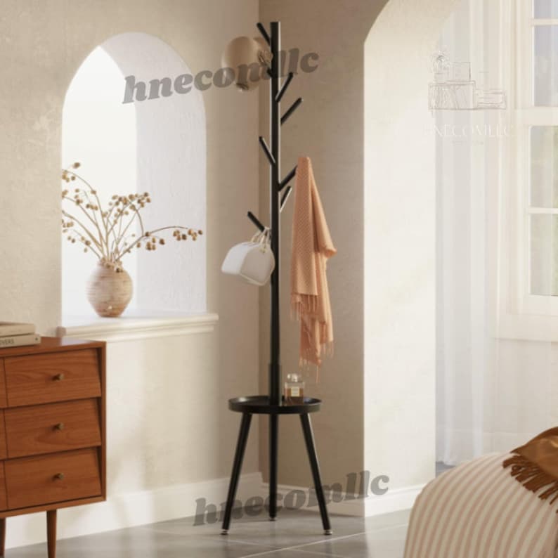 May include: Black metal coat rack with a round shelf and multiple branches for hanging clothes and accessories. The rack has a modern design and is perfect for entryways or bedrooms.