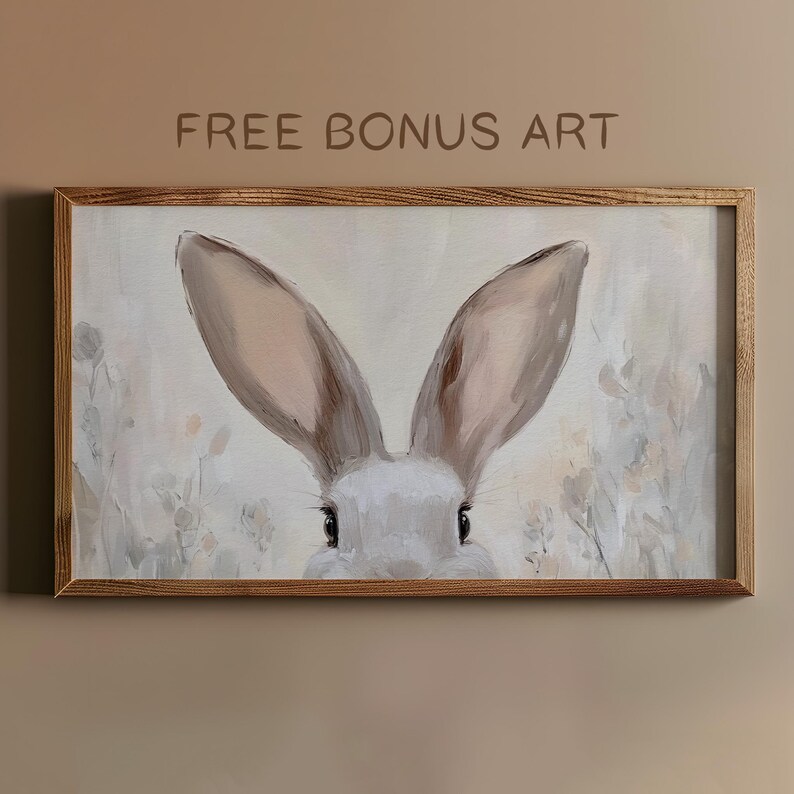 May include: A framed painting of a rabbit's face with large, soft ears. The rabbit is looking directly at the viewer with a gentle expression. The background is a soft, muted palette of beige and white.
