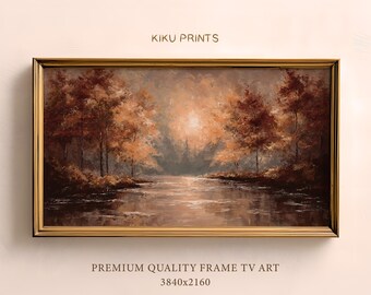 Pode incluir: Pintura de paisagem emoldurada em tons quentes, mostrando uma cena de rio com árvores outonais refletidas na água. A moldura dourada envolve a obra de arte. O texto "KIKU PRINTS" é visível.
