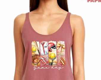 May include: A maroon tank top with a watercolor illustration of baseball equipment, including a glove, bat, ball, helmet, and popcorn. The text "Game day" is written below the illustration.
