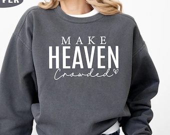 May include: A gray sweatshirt with the text "MAKE HEAVEN CROWDED" in white lettering. The text is centered on the sweatshirt and includes a small heart symbol.
