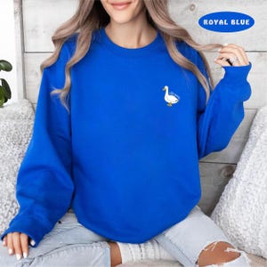 May include: A royal blue sweatshirt with a white duck and the text "silly goose" embroidered on the front.