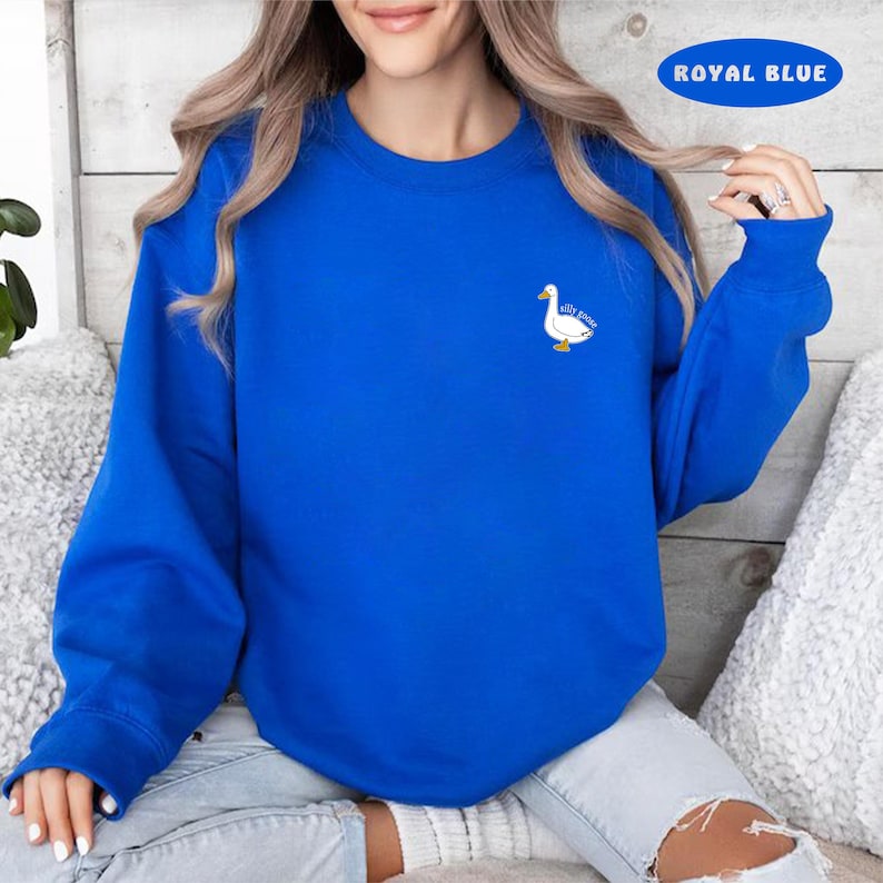 May include: A royal blue sweatshirt with a white duck and the text "silly goose" embroidered on the front.
