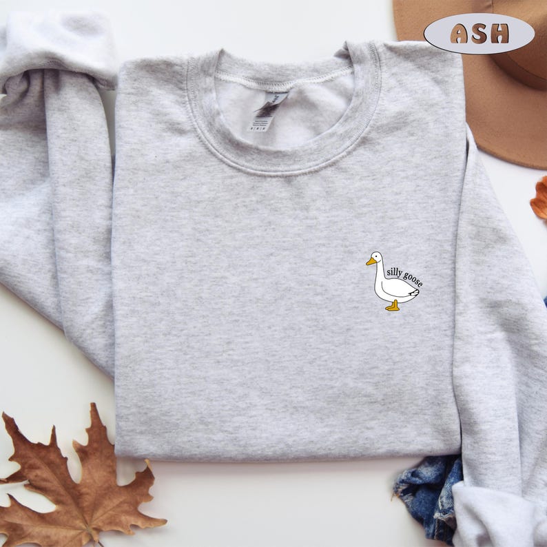 May include: A gray sweatshirt with a white goose and the text "silly goose" printed on the front.