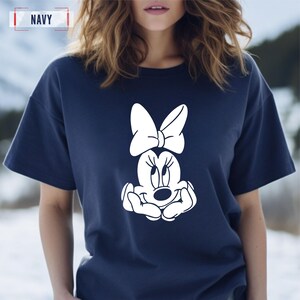 May include: A navy blue t-shirt with a white graphic of Minnie Mouse with a bow.