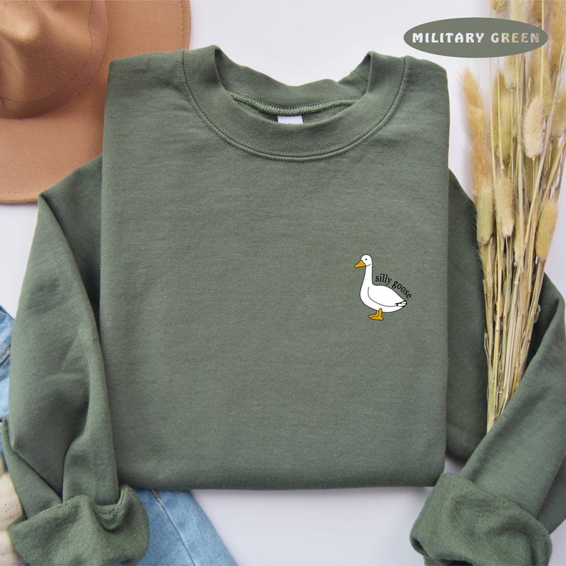 May include: A green sweatshirt with a white goose and the text "silly goose" on the front.