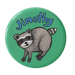 May include: A circular pinback button featuring a green background and a hand-drawn illustration of a grey raccoon with a black mask. The name Jimothy is written in blue, bold, sans-serif capital letters arched above the raccoon figure.