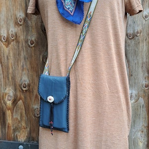 Cartera de cuero para teléfono celular adornada con un botón de asta y cuentas de vidrio checo y cosida a mano con encaje de piel de ciervo.