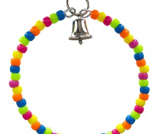May include: A colorful bird toy featuring a ring of neon-colored beads in pink, orange, yellow, green, and blue. A small silver bell hangs from the top of the ring, attached by a metal clasp. The toy is designed for birds.