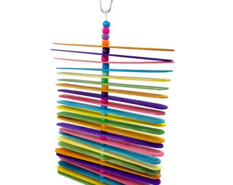 May include: A colorful bird toy made of wooden sticks in various colors, strung together with a beaded chain and a metal clasp for hanging. The toy features a variety of bright colors, including blue, green, yellow, pink, and purple.