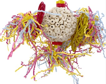 May include: A bird toy with a spherical, off-white, perforated wooden ball at its center. The ball is surrounded by colorful, crinkled paper streamers in yellow, pink, and blue. Red and yellow wooden accents are also present.