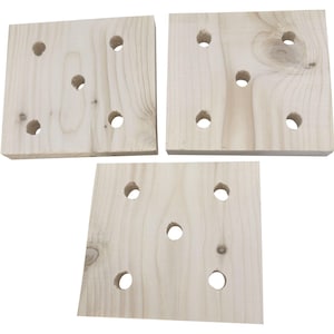 Puede incluir: Tres cuadrados de madera sin terminar con agujeros espaciados uniformemente. La veta de la madera es visible y los agujeros son circulares. Los cuadrados están dispuestos en un patrón ligeramente superpuesto, mostrando el color y la textura natural de la madera.