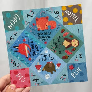 Peut inclure: Une cocotte en papier carrée avec des illustrations colorées d'un renard, d'un écureuil, d'un hibou et d'un ours. Le design inclut des textes comme You Are A Fox, You Are A Squirrel, You Are An Owl et You Are A Bear, avec des couleurs rouge, bleu, vert et jaune.