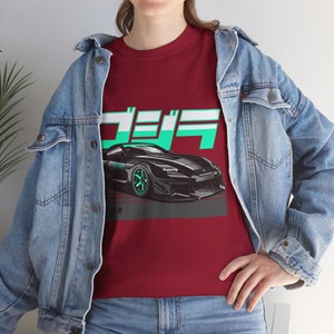May include: A red t-shirt with a black and green sports car graphic and the Japanese text "Drift" in white and green letters.