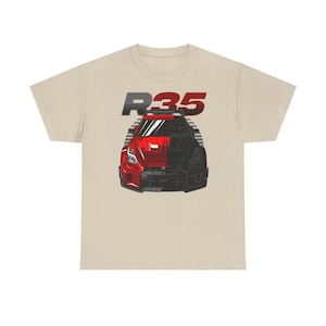 May include: A beige t-shirt with a red and black illustration of a Nissan Skyline R35 car. The car is partially obscured by a black and white graphic of the car. The text "R35" is above the car in red and black.