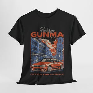May include: Black t-shirt with a graphic of a red car driving through a city street with the text "Hashiriya Gunma Japanese Domestic Market" printed on the front.