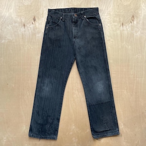May include: Dark wash denim jeans with a straight leg cut. The jeans have a button and zipper closure, classic five-pocket design, and a patch on the right knee. The denim has a faded appearance.