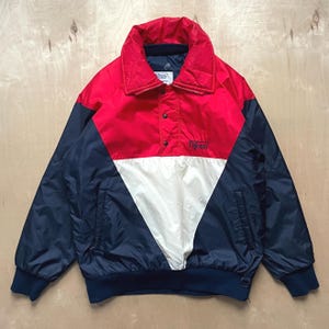 May include: A vintage colour-block jacket in red, navy blue, and white. The jacket features a collared neckline, snap closures, and a ribbed hem and cuffs. The brand name "Difrani" is printed on the front.