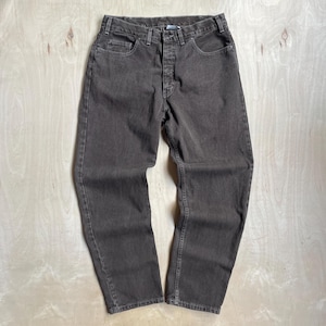 May include: A pair of charcoal gray denim jeans featuring a classic five-pocket design, a button fly closure, belt loops at the waistband, and visible tonal stitching throughout the garment. The jeans have a straight-leg cut and a medium rise.
