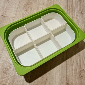 Peut inclure: Un plateau en plastique vert avec six compartiments blancs amovibles. Le plateau est conçu pour organiser de petits objets.