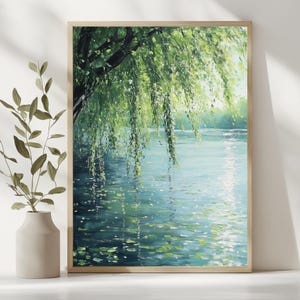 May include: A framed painting depicts a serene waterscape. A weeping willow tree with vibrant green leaves hangs over the water, its reflection shimmering on the surface. The artwork is encased in a light-colored wooden frame, adding a touch of natural elegance.