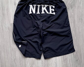 Pantaloncini vintage Nike neri in nylon con grande logo Nike Swoosh ricamato, anni 2000.