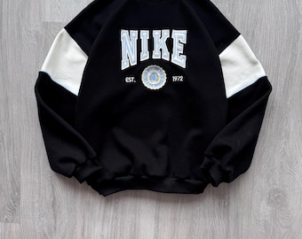 Sudadera vintage Nike de los 90, negra, holgada, con cuello redondo y gran logo Swoosh bordado en el centro. Y2K.