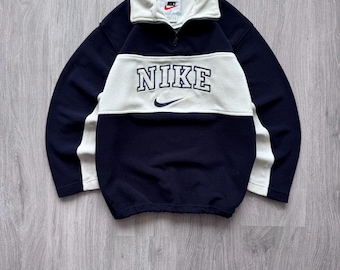 Sudadera vintage Nike de los 90 con forro polar, media cremallera y gran logo Nike bordado en el centro.